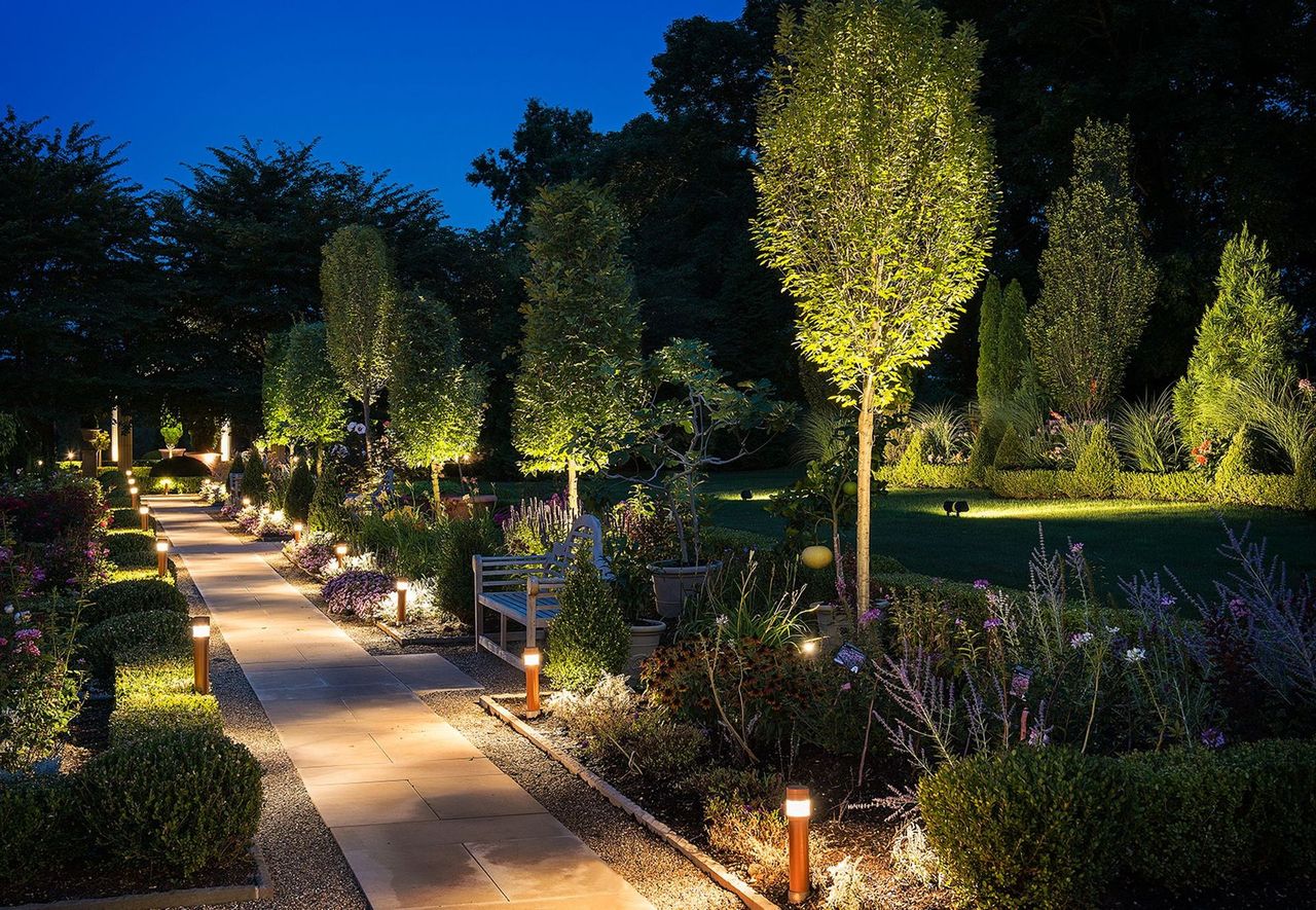 Formal garden path lit with bollard lights at dusk